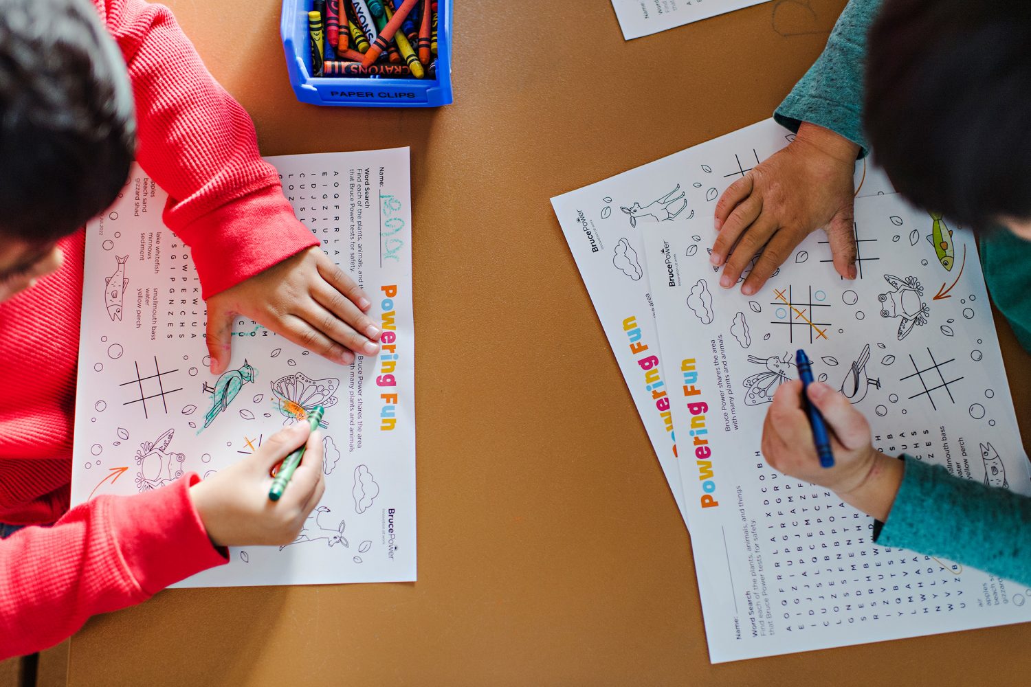 Children colouring in a nature-themed activity sheet at the Bruce Power Visitors’ Centre.