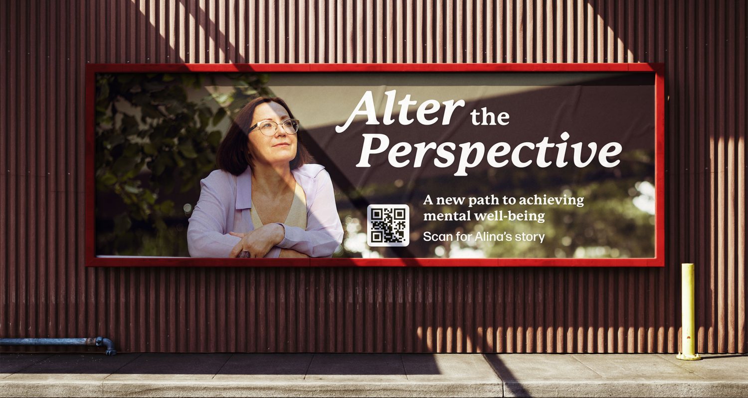 Alter the Perspective billboard that reads, "A new path to achieving mental well-being. Scan for Alina's story," on the side of a building.